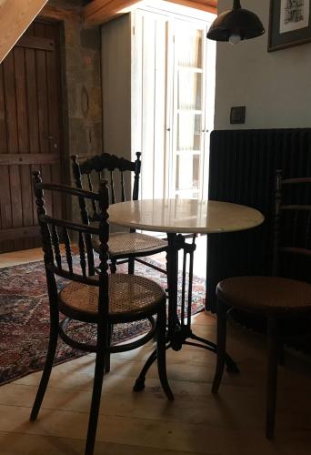 a table and chairs in a room with a table and a chair at Montanema Handmade Village in Platanákos