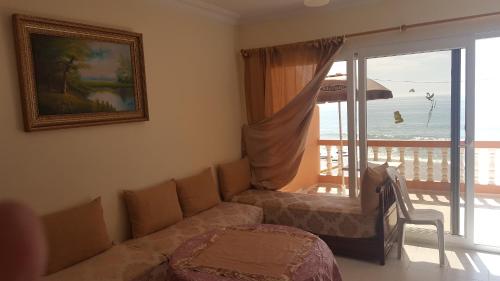 a living room with a couch and a view of the ocean at Surfapartment Taghazout Nr 6 in Taghazout