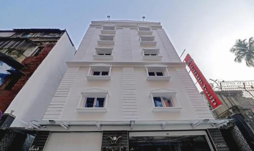 wysoki biały budynek z oknami w obiekcie Treebo Trend Orion Sapphire w mieście Ballygunge