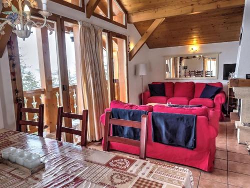 un salon avec un canapé rouge et une table dans l'établissement Chalet Chamois, à Landry