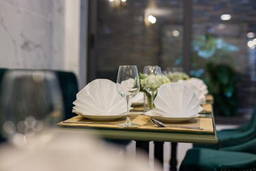 a table with plates and wine glasses on it at Hanoi Amorita Boutique Hotel & Travel in Hanoi