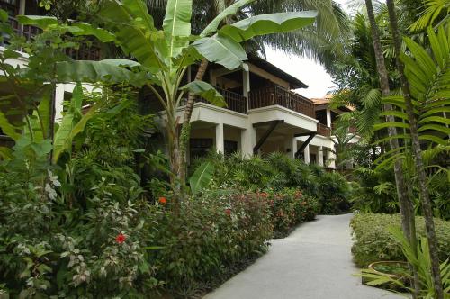 a walkway leading to a resort building with plants at Avillion Port Dickson in Port Dickson