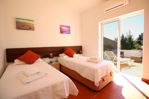 een slaapkamer met 2 bedden en een balkon bij Townhouse Mia Panoramic views Communal Pool in Carvoeiro