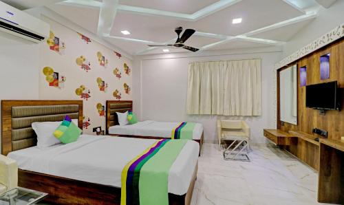 a hotel room with two beds and a tv at Treebo Orion Sapphire, Beck Bagan in Kolkata