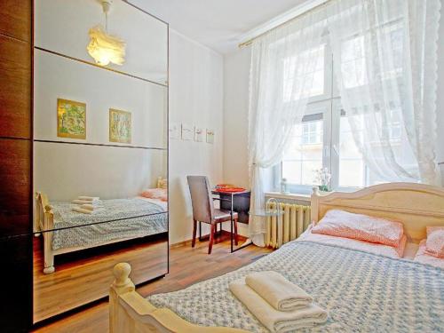 sypialnia z łóżkiem, stołem i oknem w obiekcie Apartament Kameralny przy ulicy Długiej w Gdańsku