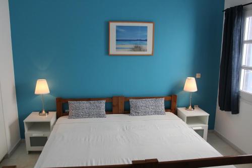 a blue bedroom with a large bed with two night stands at Villa Irenes Dream - For dreamy holidays in Mikri Vigla
