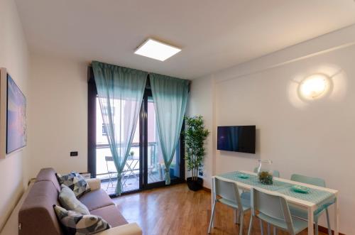 een woonkamer met een bank en een tafel bij DOCK OF THE BAY GENOVA- Appartamento situato nel porto antico di Genova- Aria Condizionata- Garage privato-Vista sul porto in Genua