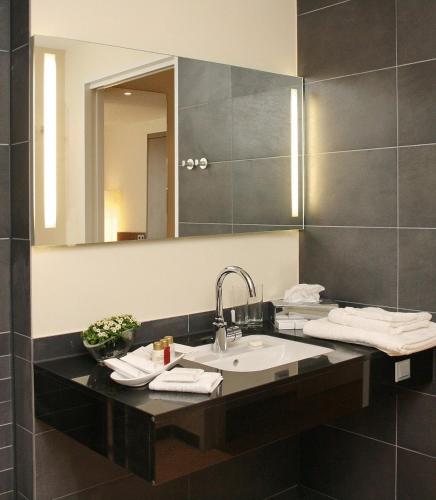 a bathroom with a sink and a mirror at Hotel Klostergarten in Kevelaer