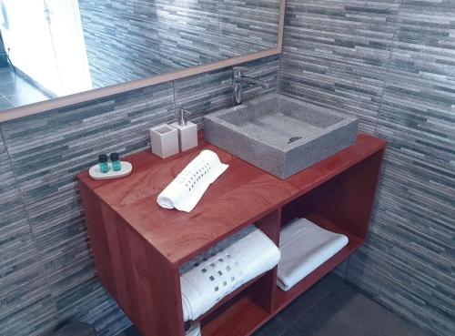 a bathroom with a sink and a mirror at 2 0 HÔTEL Vanille in Dzaoudzi