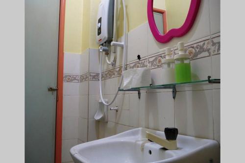 a bathroom with a sink and a mirror at Colourful homestay - (near jeti sky mirror) in Kuala Selangor