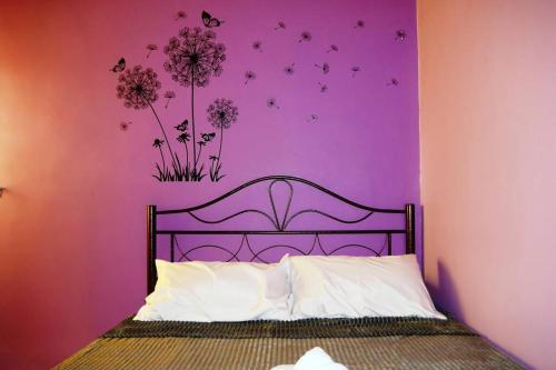 a bedroom with a bed with a purple wall at Colourful homestay - (near jeti sky mirror) in Kuala Selangor