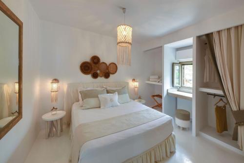 ein weißes Schlafzimmer mit einem großen Bett und einem Fenster in der Unterkunft Executive Paros Villa 4 Bedrooms Villa Almyrikia Sunset Stunning Sea View in Kampos Paros
