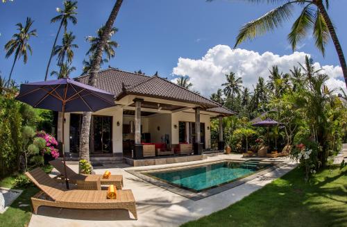 a villa with a swimming pool and a house at Villa Barong in Candidasa