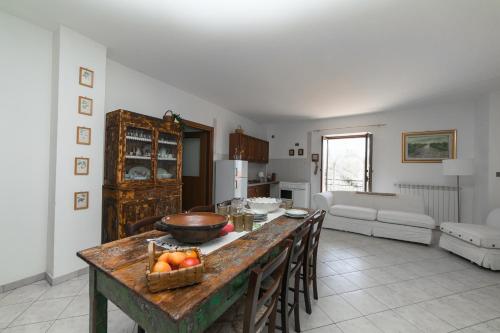 een keuken en een woonkamer met een tafel met een fruitschaal bij Adelina e il bosso in Policastro Bussentino