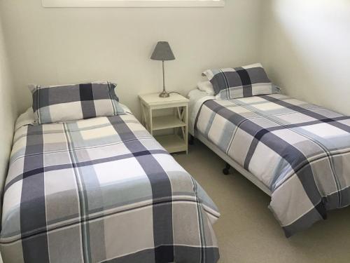 dos camas sentadas una al lado de la otra en una habitación en Swansea Beach House Oceanfront, en Swansea