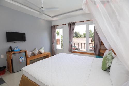 a bedroom with a large bed and a window at MAY Bungalow in Mui Ne
