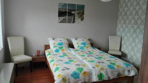 uma cama com um edredão num quarto em Ferienwohnung Natur und Steine em Oberbrombach