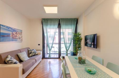 sala de estar con sofá y mesa en DOCK OF THE BAY GENOVA- Appartamento situato nel porto antico di Genova- Aria Condizionata- Garage privato-Vista sul porto, en Génova