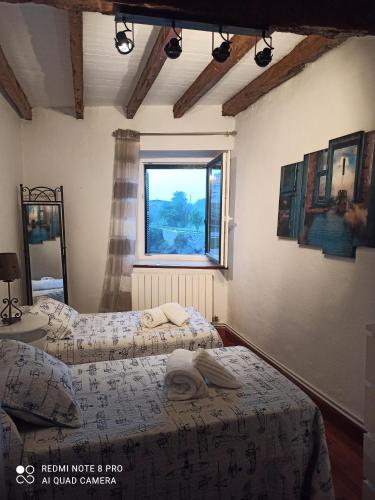 two beds in a room with a window at Vive el puerto con párking privado GRATUITO!!! in Mundaka