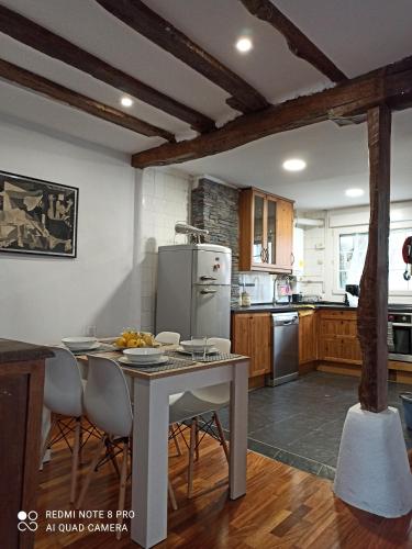 a kitchen with a table with chairs and a refrigerator at Vive el puerto con párking privado GRATUITO!!! in Mundaka
