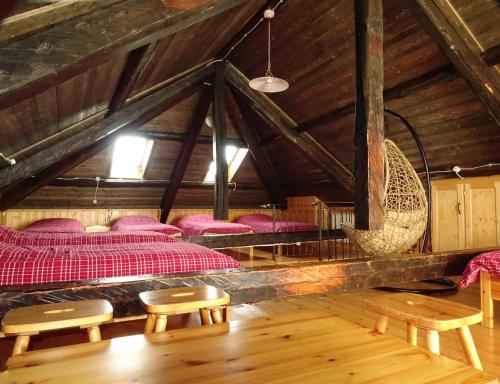 a room with beds and chairs in a attic at Baita Casera Caviazza in Falcade