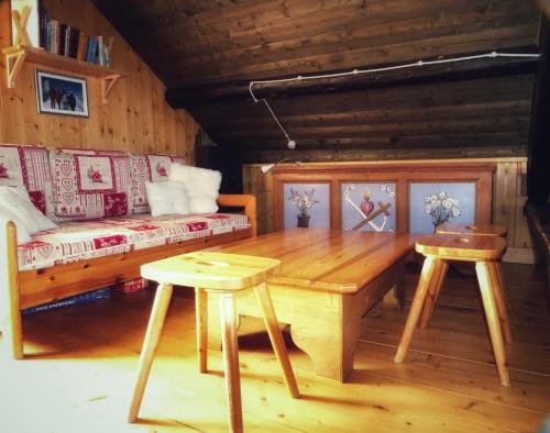 a living room with a wooden table and a couch at Baita Casera Caviazza in Falcade