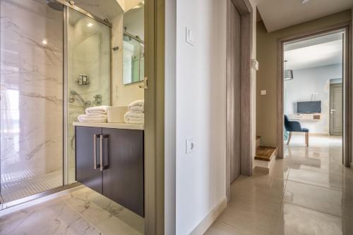 a bathroom with a walk in shower and a glass door at Beachfront Zante Villa Villa Perla 5 Bedroom Private Pool Tragaki in Planos