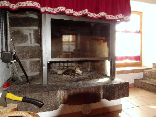 a fireplace with a chicken laying inside of it at Baita Casera Caviazza in Falcade