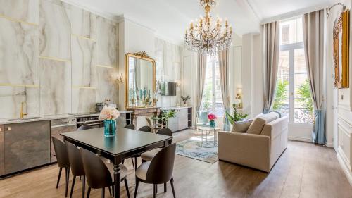 a living room with a table and chairs and a chandelier at Luxury 3 Bedroom 2 Bathroom Palace Apartment - AC - Louvre in Paris