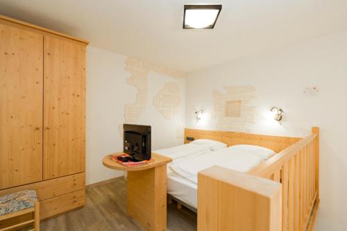 a bedroom with a bed and a tv on a table at HOTEL B&B MARILENA in Arabba