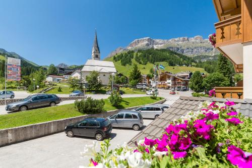 a view of a town with cars parked in a parking lot at HOTEL B&B MARILENA in Arabba