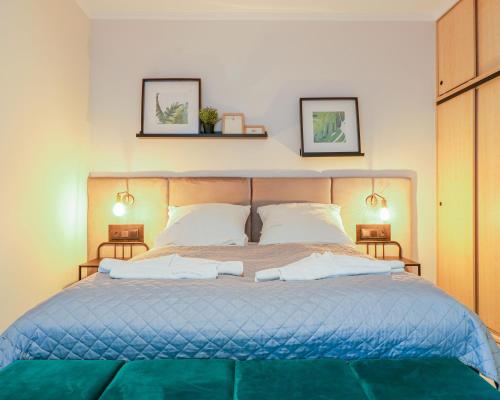 a bedroom with a blue bed with two pictures on the wall at Regina Maris by Baltic Home in Świnoujście