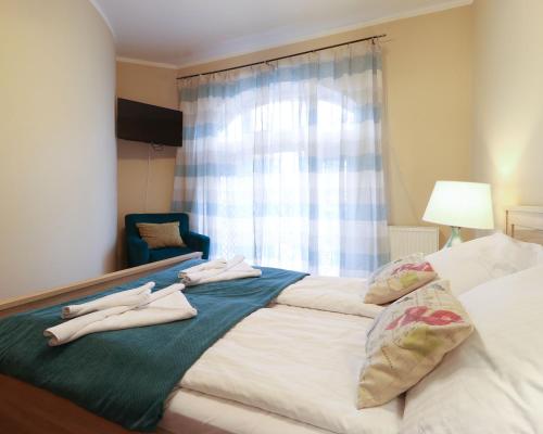a bedroom with a bed with two towels on it at Regina Maris by Baltic Home in Świnoujście