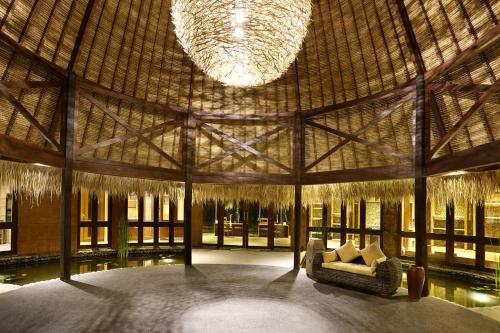 a large room with a couch and a large chandelier at WakaGangga in Tabanan