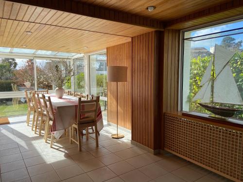 une salle à manger avec une table et des chaises et une grande fenêtre dans l'établissement Le Huic maison de marin lambrissée, à Bénodet
