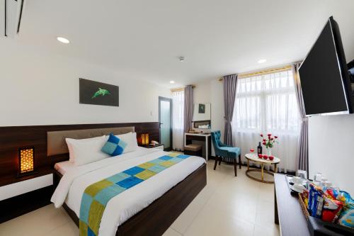 um quarto de hotel com uma cama grande e uma secretária em Phuc Thanh Luxury Hotel by THG em Da Nang