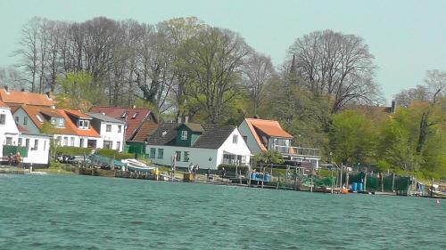 un groupe de maisons sur la rive d'une masse d'eau dans l'établissement Domhotel Bed & Breakfast, à Schleswig