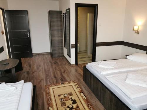 a bedroom with two beds and a wooden floor at Hotel Tranzit in Odorheiu Secuiesc