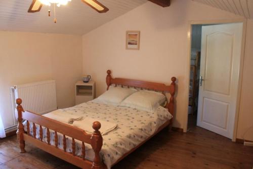 ein Schlafzimmer mit einem Holzbett in einem Zimmer in der Unterkunft Pegasus, Les Constellations in Doeuil-sur-le-Mignon