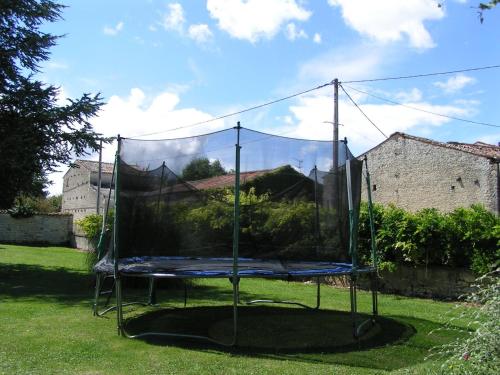 a net on a trampoline in a yard at Gite Andromeda - Les Constellations in Doeuil-sur-le-Mignon