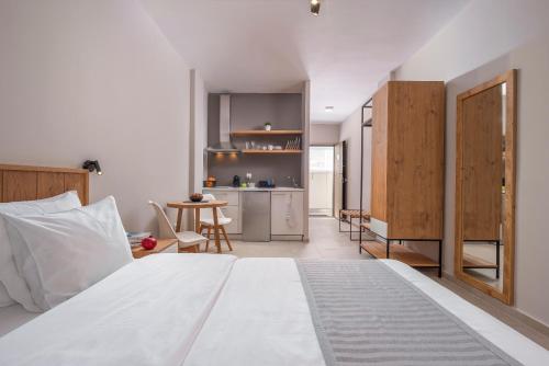 a bedroom with a white bed and a kitchen at Your City Level in Thessaloniki