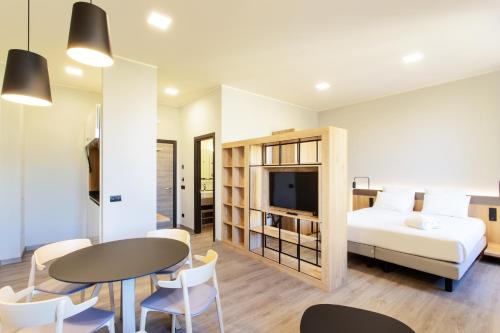 um quarto com uma cama, uma mesa e cadeiras em Palazzo Le Poste - Suite and Apartments em Parma