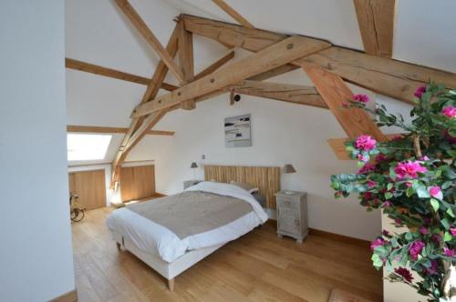 a bedroom with a bed in a room with wooden beams at Maison charmante au cœur d'Alligny-en-Morvan avec vue in Alligny-en-Morvan