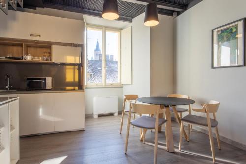 a kitchen and dining room with a table and chairs at Palazzo Le Poste - Suite and Apartments in Parma