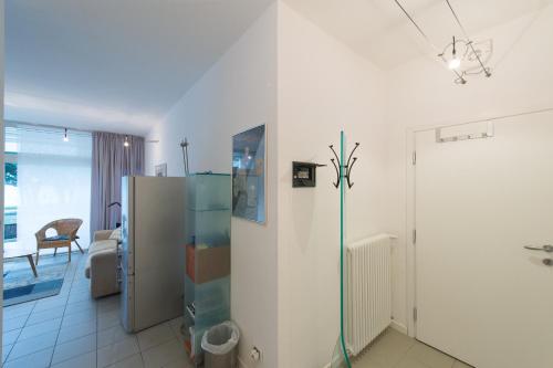 a kitchen with a refrigerator and a living room at Appartamento Fronte Lago in Riva del Garda
