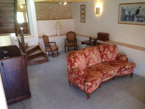 a living room with a red couch and chairs at Gemini, Les Constellations Gite Complex in Doeuil-sur-le-Mignon