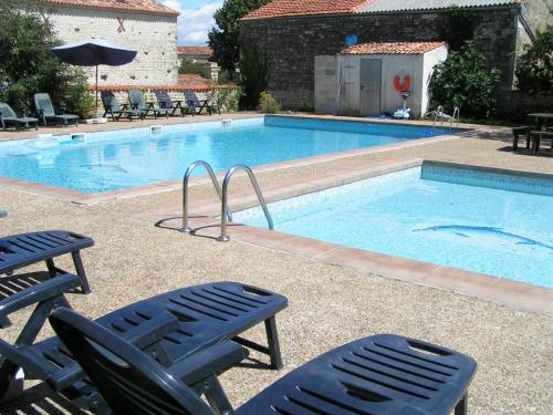 a swimming pool with two lawn chairs and two chairsitures at Saggitarius, Les Constellations in Doeuil-sur-le-Mignon