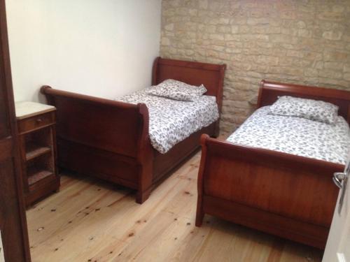 two beds in a room with wooden floors at Saggitarius, Les Constellations in Doeuil-sur-le-Mignon
