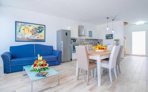 a living room with a blue couch and a table at Jacuzzi Holiday Homes by LoveSud in Leuca