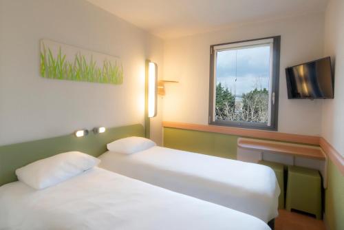 a hotel room with two beds and a window at ibis budget Antwerpen Port in Antwerp
